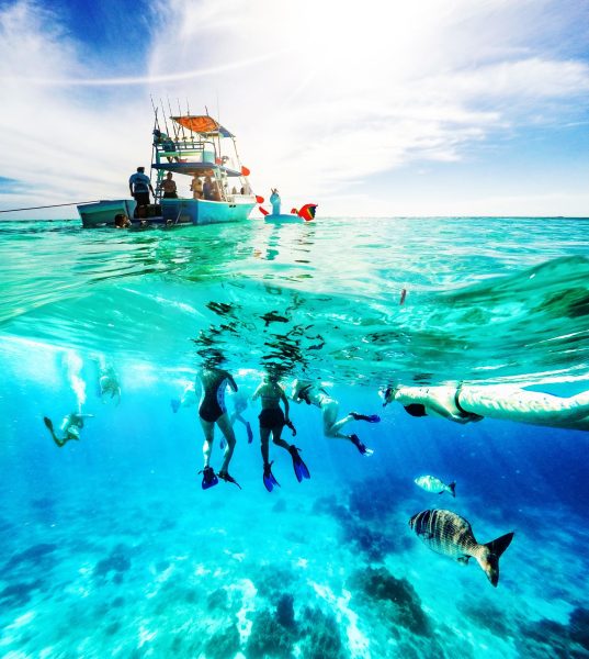 Group of friends on a Carribean Sea adventure with party boat, snorkeling and scuba diving